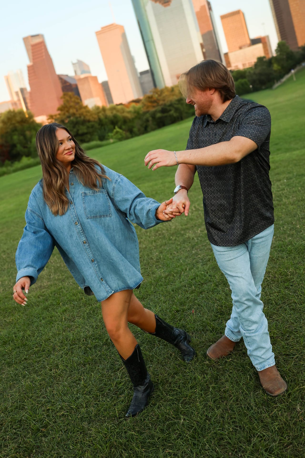Couple holding hands with the Houston skyline behind
