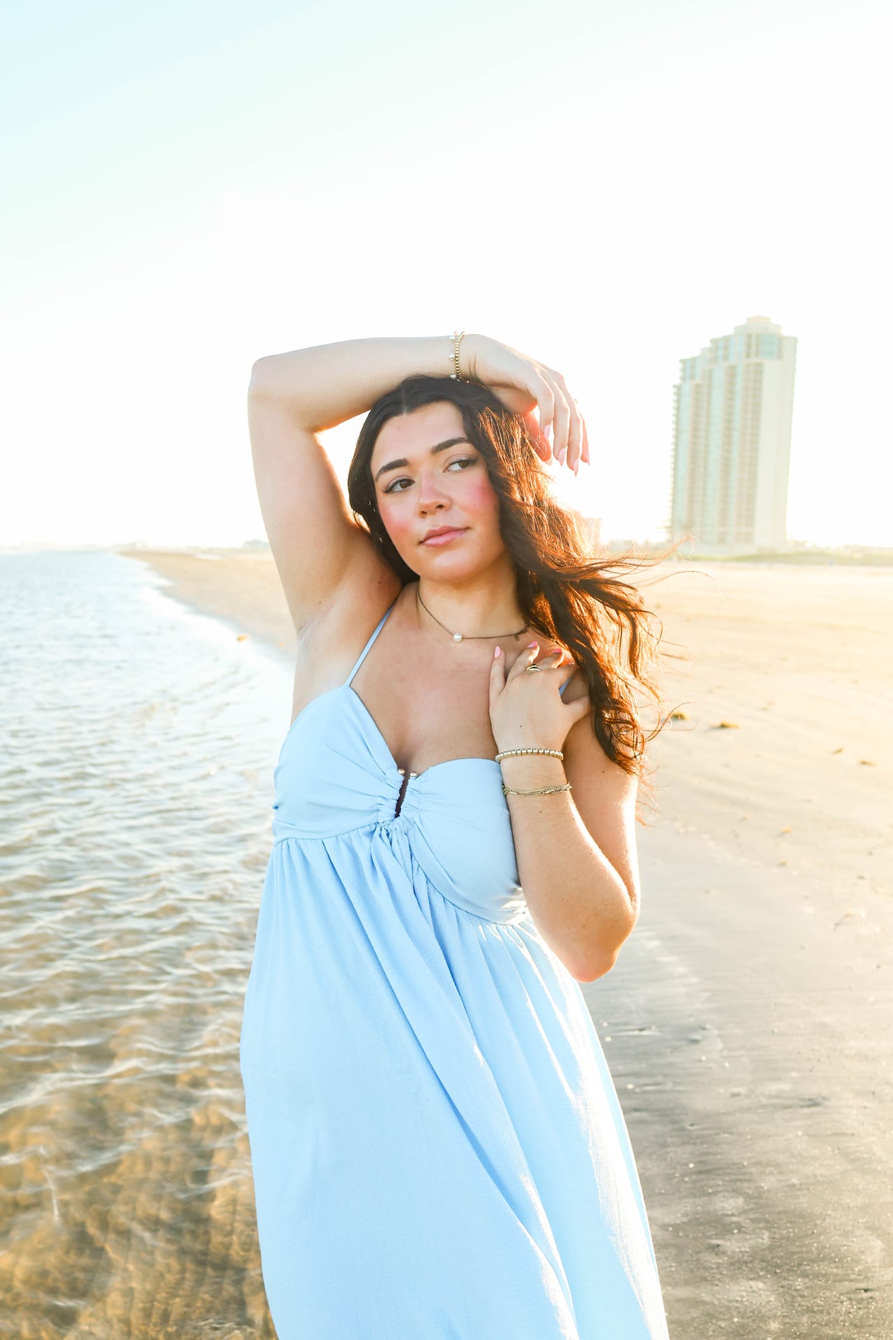 Senior in light blue dress at the beach at sunset