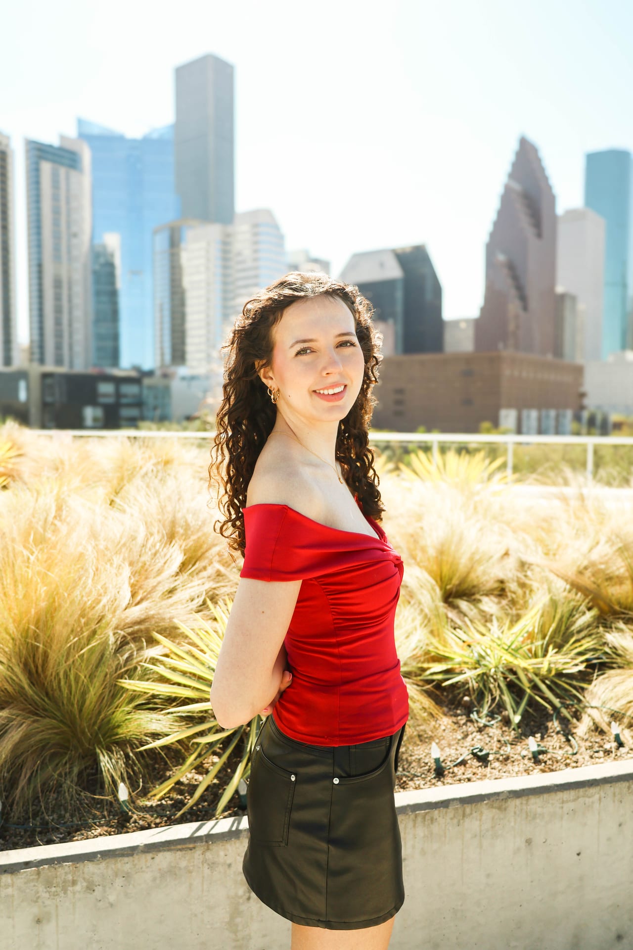 Senior in red top with the Houston downtown skyline